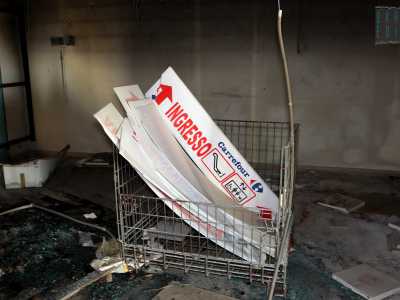 A poca distanza riposa un carrello della spesa colmo di quei cartelli che guidavano il cliente all'interno dell'ipermercato